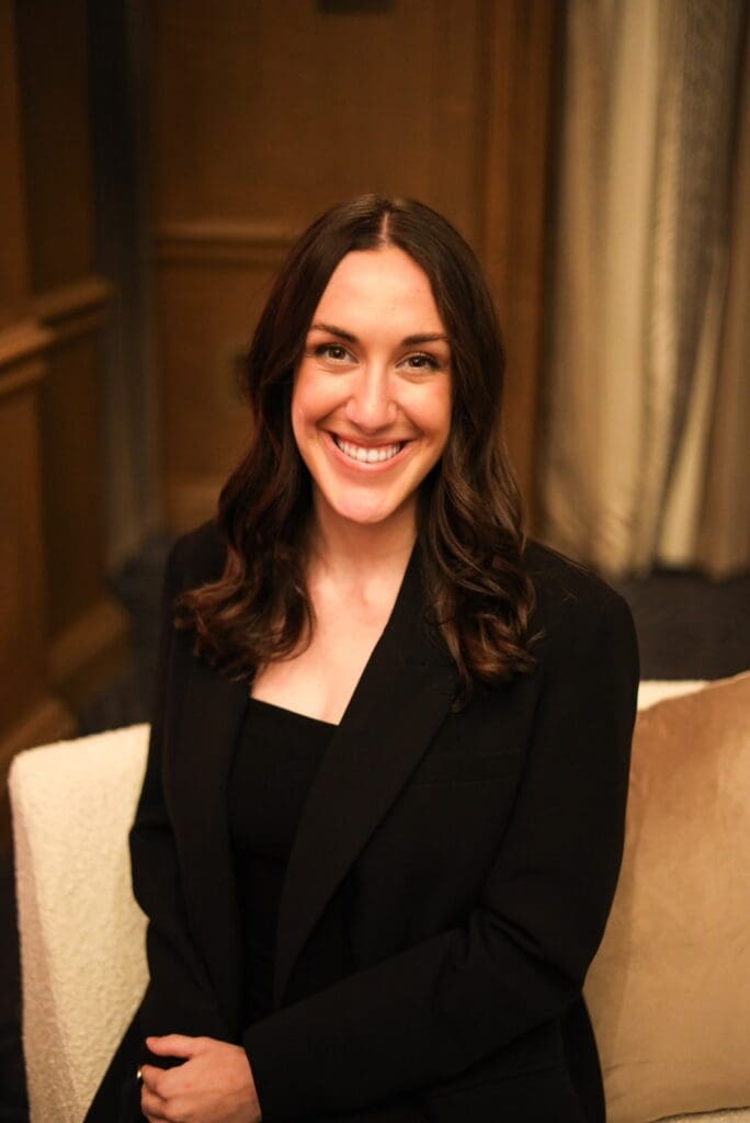A woman in black jacket sitting on chair.