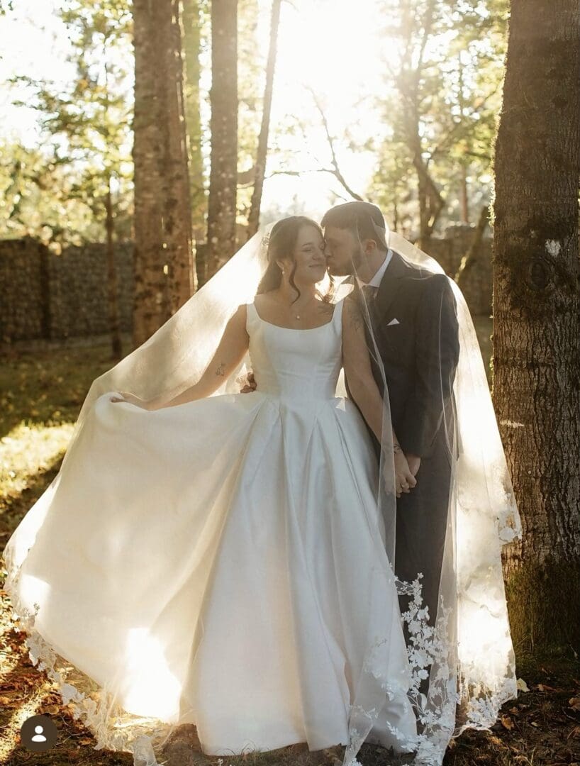 Anabelle and Josh sharing a romantic moment beneath her flowing veil at Red Cedar Farm in Washington.