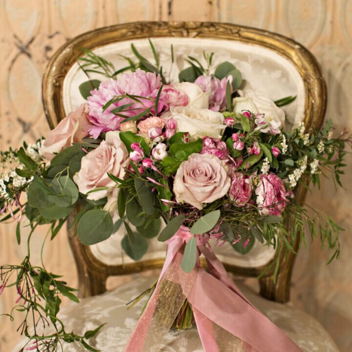 A bouquet of flowers sitting on top of a chair.
